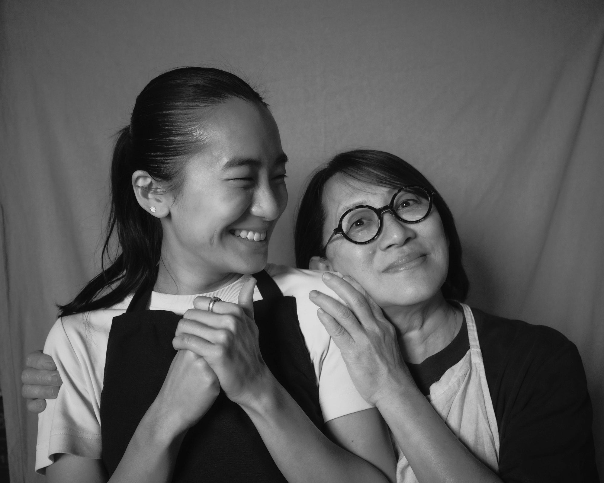 Xien and her mother Jolene laughing together in a black-and-white portrait